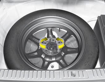 Turn the tire hold-down wing bolt counterclockwise.